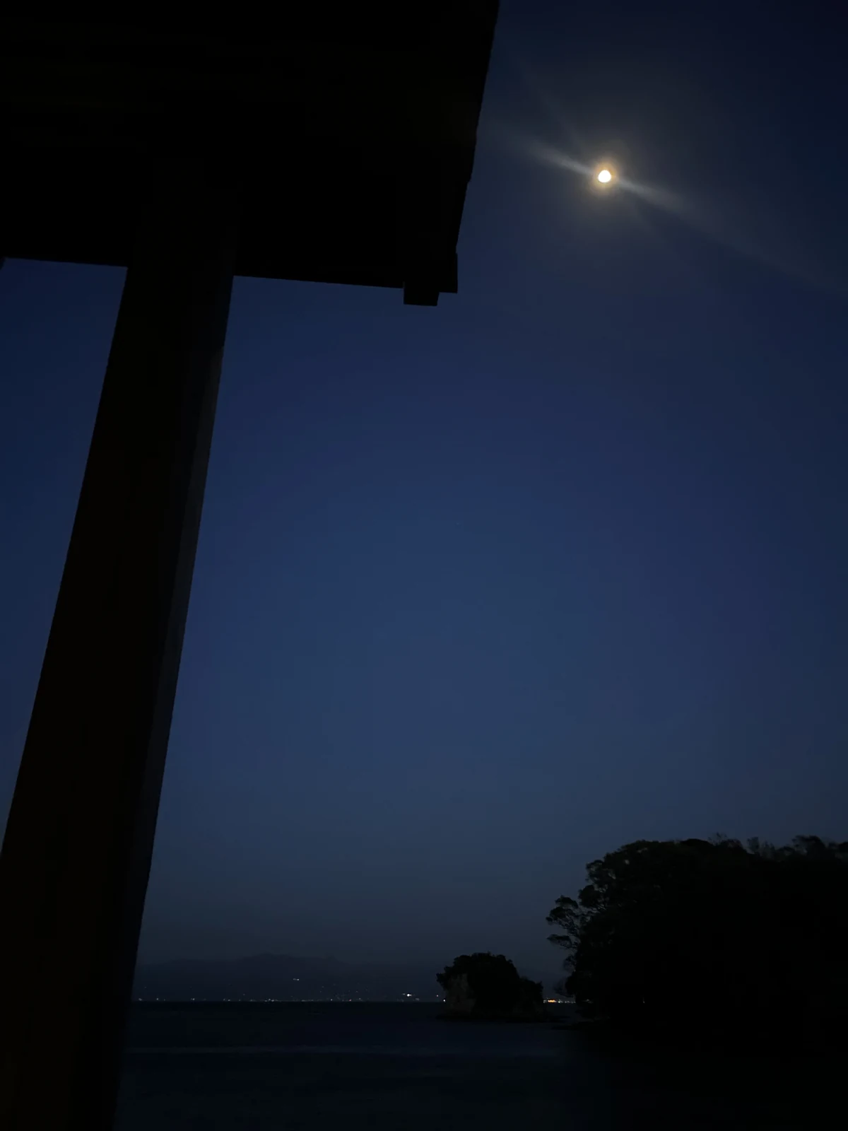屋根の下から見上げる、夜空に浮かぶ満月